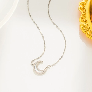Silver moon pendant necklace with shimmering crystals and mother of pearl on white background