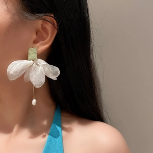 Detailed close-up of long organza flower drop earrings with pearls and gold pins