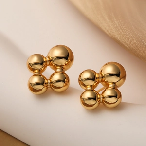 Polished 18K gold plated cluster bead earrings with four spherical balls on a white stand