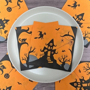 Halloween napkins featuring orange wizard castle and witch silhouettes on a wooden table