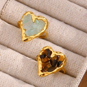 Macro detail of 18K gold plated heart rings with green and brown tiger eye stones