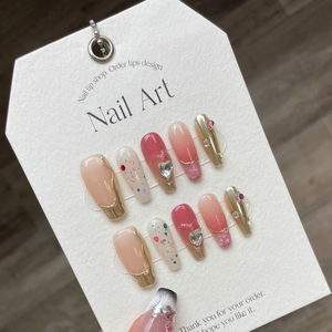 Handmade burgundy and gold press-on nails with 3D heart charms and glitter details