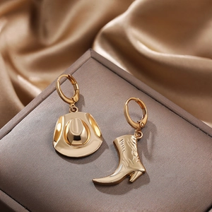 Detail of 18K gold plated asymmetric earrings with cowboy boot and hat charms on silk