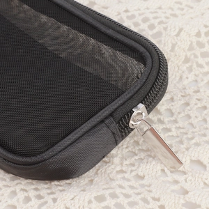Dettaglio della cerniera in metallo e del tessuto a rete nero della trousse