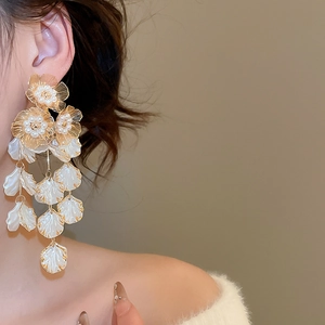 Detail of vintage flower tassel earrings with pearls and white petals on model