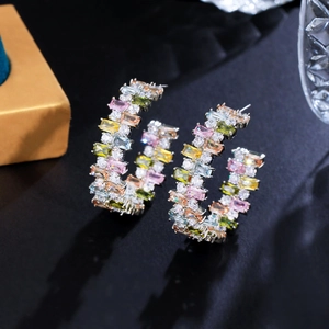 Macro shot of colorful rectangular cubic zirconia and pave white diamonds on hoop earrings