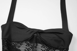 Detail eines schwarzen Neckholder-Kleids mit Knotendesign und Spitzenbesatz vorne