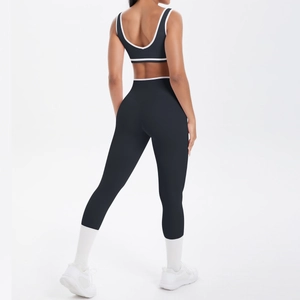 Detailansicht der Rückseite des schwarzen Yoga-Sets mit weißer Kontrastpaspel und Leggings