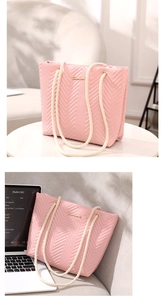 Detail of pink quilted tote bag with woven rope handles and gold metallic logo