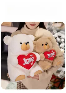 Detail of soft teddy bears with red Love hearts held by a model in a cozy setting