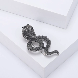 Macro detail of cobra brooch with vintage silver finish and grey rhinestones