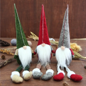 Three Christmas gnomes in red, green, and grey with long legs on a rustic wooden background