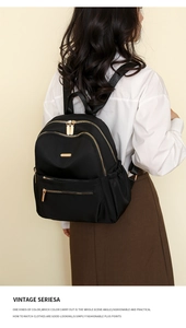 Rear view of a black nylon backpack for women featuring large capacity and gold zippers