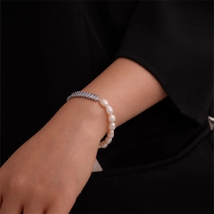 Detail of elegant pearl bracelet with cubic zirconia inlay on a female wrist