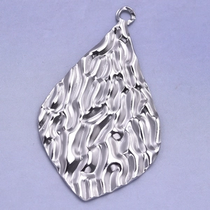 Macro shot of silver 304 stainless steel oval textured pendant with hammered finish