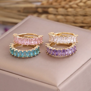 Detail of multi-colored square zircon rings in gold adjustable bands on a jewelry box