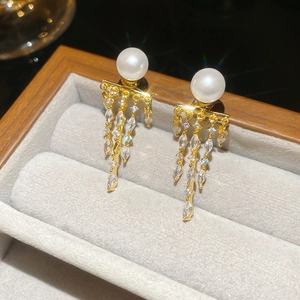 Macro shot of 14K gold plated earrings with pearls and marquise zircons in a jewelry box