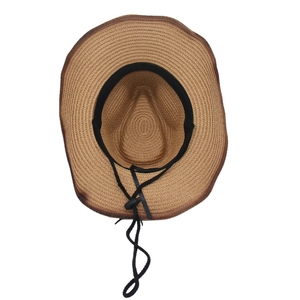 Detail of khaki straw cowboy hat showing woven texture, inner sweatband and wind rope