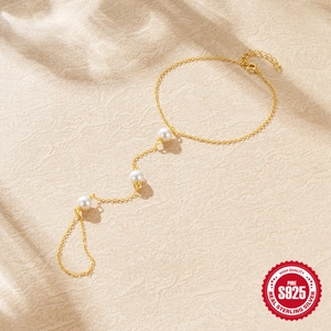 Elegant S925 sterling silver finger bracelet with white pearls on a textured background