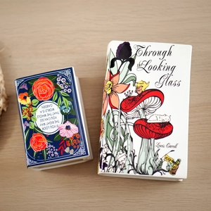 Creative book-shaped ceramic flower vases with literary illustrations on wooden tabletop