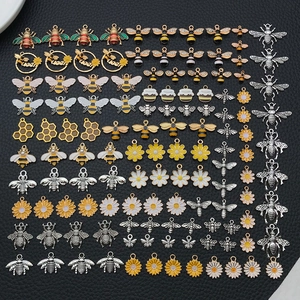 Detailed assortment of bee, honeycomb, and daisy alloy charms with enamel and rhinestones
