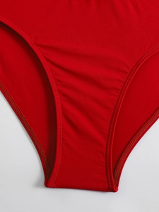 Detailed macro view of the high-quality stitching on high-waist red bikini bottoms