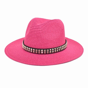 Detail of fuchsia woven straw jazz hat featuring black band and silver square studs