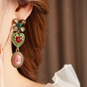 Boucles d'oreilles vintage dorées avec trèfle vert et camée rose portées par un mannequin