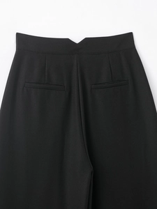 Détail du pantalon noir à taille haute avec fente en V au dos et poches passepoilées