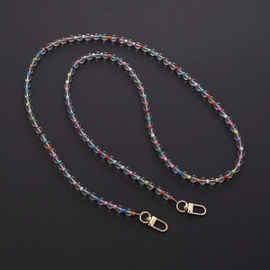 Detail of acrylic bead crossbody strap with colorful beads and golden metal clasps