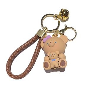 Portachiavi a forma di orso in resina con cinturino in pelle intrecciata e campanellino d'oro