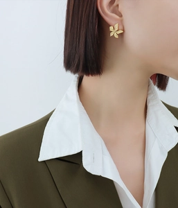 Model wearing gold petal textured earrings in 18k gold plated stainless steel