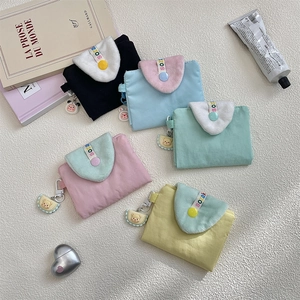 Detailed view of pastel card holders with plush trim and cute cartoon animal charms