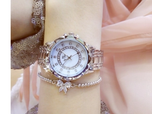 Close-up of women's silver watch with rhinestone-encrusted floral mother-of-pearl dial