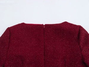 Gros plan sur la fermeture éclair invisible du col arrière de la robe en tweed rouge