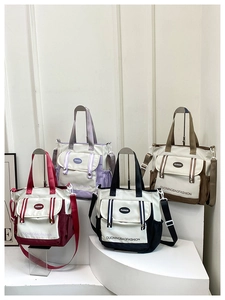 Detail view of canvas bucket bags in red purple black and brown with multiple pockets