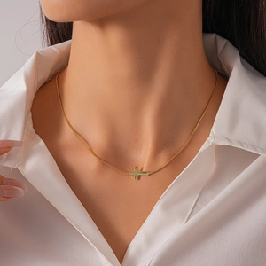 Close-up of minimalist 18k gold plated horizontal cross necklace on model