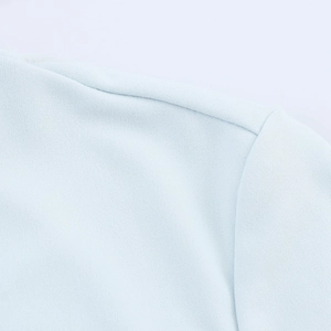 Dettaglio della trama del tessuto azzurro e della cucitura sulla spalla del vestito