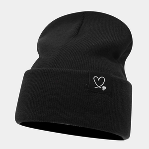 Gros plan détaillé d'un bonnet en maille noire avec un écusson cœur élégant