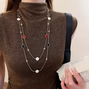 Gros plan d'un collier vintage double couche avec breloques en résine sur un mannequin