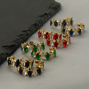 Detail of C-shaped stainless steel gold earrings set with colorful marquise zircons