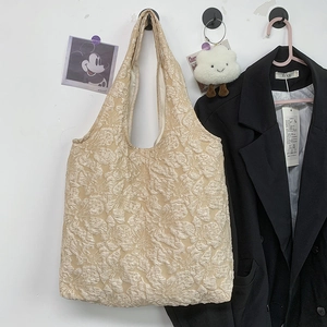 Close-up of floral jacquard texture on beige minimalist canvas shoulder tote bag