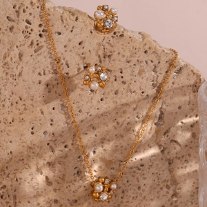 Detail of 18K gold-plated necklace and stud earrings set with pearls and rhinestones