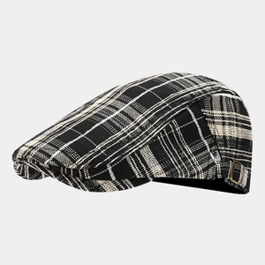 Detailed macro of vintage plaid flat cap featuring brass buckle and woven fabric texture
