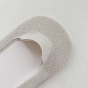 Detail von gerippten beigen Füßlingen mit elastischen Bündchen und weicher Baumwollstruktur