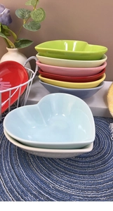 Stack of colorful heart-shaped ceramic dessert bowls in various pastel and vibrant tones