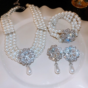Macro shot of clover-shaped jewelry set with white pearls and sparkling diamonds