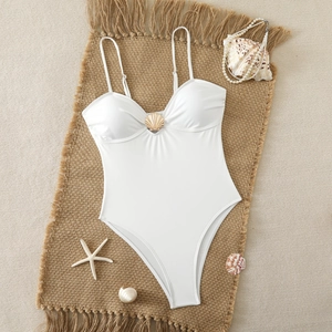 White one-piece swimsuit featuring a golden shell buckle and elegant thin straps