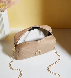 Top view of quilted leather bag interior showing zipper and gold chain detail