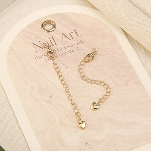 Detailed close-up of 18k gold plated extension chains with lobster clasps and heart charms
